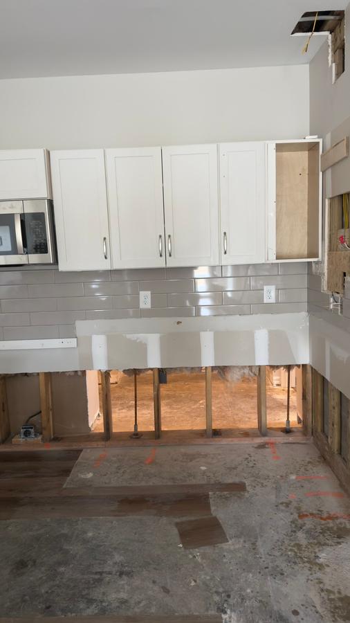 Water damaged kitchen with flooring removed and drywall cut — water restoration Panama City