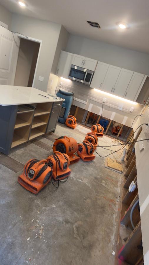 Industrial air movers deployed in water damaged kitchen — structural drying Panama City FL